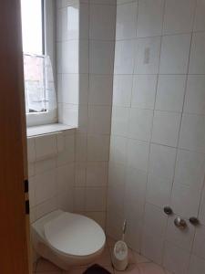 ein Badezimmer mit weißer Toilette und Fenster in der Unterkunft Beim Dobis in Lutzingen
