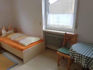 ein kleines Schlafzimmer mit einem Bett und einem Fenster in der Unterkunft Beim Dobis in Lutzingen + 5 Fotos