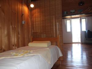 1 dormitorio con 1 cama en una habitación con paredes de madera en Apartments Ljubo - 15m from the sea, en Stara Novalja