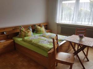 ein kleines Schlafzimmer mit einem Bett und einem Tisch in der Unterkunft Beim Dobis in Lutzingen