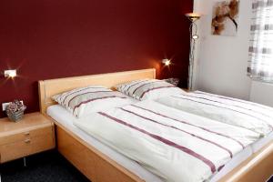 a bed with two pillows on it in a bedroom at Landgasthaus Badischer Hof in Großrinderfeld