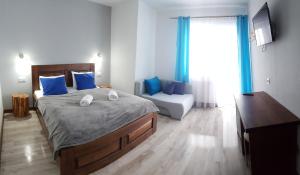 1 dormitorio con cama con almohadas azules y sofá en Villa Krzesanica, en Czarna Góra