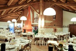 una sala da pranzo con tavoli e sedie bianchi di Locanda Ca'Vejo srl a Megliadino San Vitale
