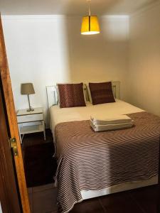 a bedroom with a large bed with a lamp and a table at Casa da Avó Tina - Apartamento in Castelo de Vide