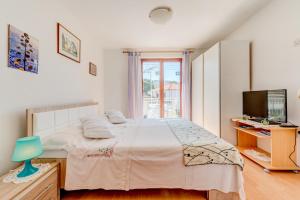 a bedroom with a large bed and a television at Apartment Anic in Stari Grad