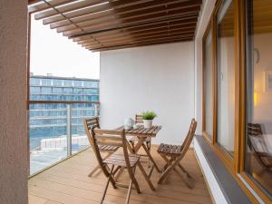 a balcony with a wooden table and chairs on it at VacationClub – Olympic Park Apartament B402 in Kołobrzeg