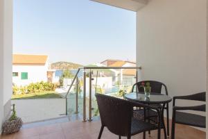a patio with a table and chairs on a balcony at Villa Sunset in Rogoznica