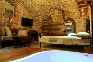 a bedroom with two beds in a room with stone walls at Ashash House in Acre