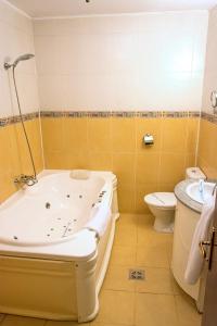a bathroom with a tub and a toilet and a sink at Voila Inn in Constanţa