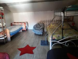 a room with two bunk beds and a red star on the floor at Le Pressoir in Saint-Julien-de-Coppel +10 photos
