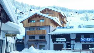 un edificio con la neve sopra di esso di Residence & Wellness 3MILA a Peio Fonti