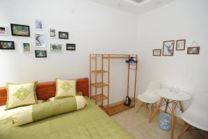 um quarto com uma cama verde e quadros na parede em Ruby Lakeview homestay em Hanói