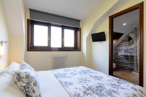 1 dormitorio con cama, ventana y escalera en Casa do Marqués en Baiona