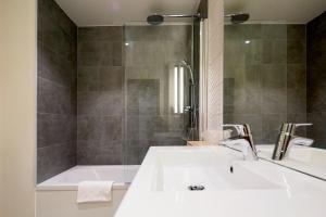 a bathroom with a sink and a bath tub at Campanile Orléans Centre Gare in Orléans +27 photos