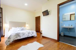 1 dormitorio con cama y lavamanos en Casa do Marqués, en Baiona