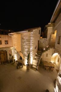 un edificio con escaleras, una mesa y luces en terracota hotel en Nevşehir