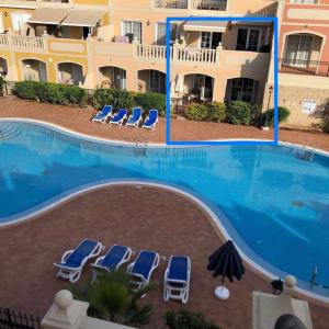 una piscina con tumbonas y un hotel en Orion, en Palm-mar