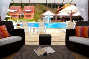 a patio with two chairs and a swimming pool at Hotel Girassol in Penedo