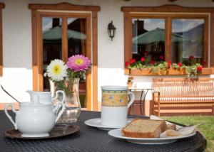 a table with a tea pot and a plate of bread at Pension Silberbauer in Lohberg