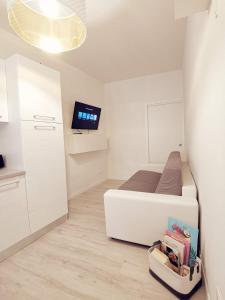 a living room with a television and a bed at Dolce Riva Downtown apartment in Riva del Garda