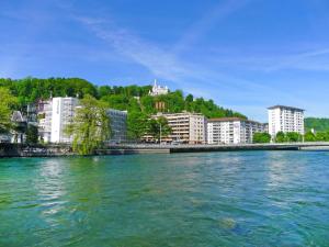 uma grande massa de água com edifícios ao fundo em Apartment BHMS City Campus by Interhome em Lucerna