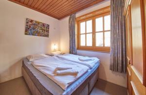 a small bed in a room with a window at Appartement Bernkogel in Saalbach Hinterglemm