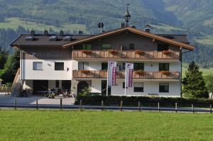 a large white building with a balcony at Haus Piesendorf in Piesendorf