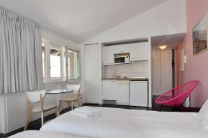 a bedroom with a bed and a table and chairs at Temporesidence Chateauneuf in Bayonne