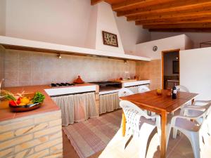 eine Küche mit einem Holztisch und weißen Stühlen in der Unterkunft Holiday Home Vicent by Interhome in Serrallonga