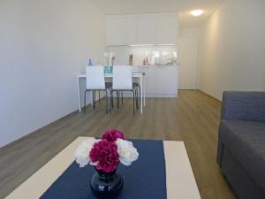 een woonkamer met een tafel en een vaas met bloemen bij Apartment BHMS City Campus by Interhome in Luzern