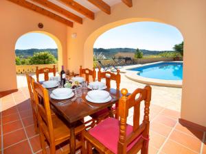 ein Esszimmer mit einem Tisch und einem Pool in der Unterkunft Holiday Home Vicent by Interhome in Serrallonga
