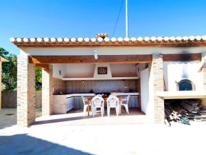 eine Terrasse mit Stühlen und eine Küche in einem Haus in der Unterkunft Holiday Home Vicent by Interhome in Serrallonga