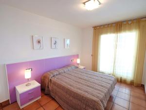 1 dormitorio con 1 cama, 2 lámparas y ventana en Apartment Playasol 1 by Interhome, en Les Cases d'Alcanar