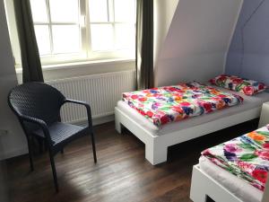 una camera con due letti e una sedia e una finestra di Design Apartment a Berlino