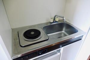 una cocina con fregadero y estufa en FWA Guest House, en Fujinomiya