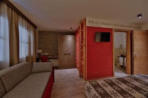 トゥエンノにあるChalet Tovel - Mountain Lakeのソファと赤いドアが備わるホテルルーム