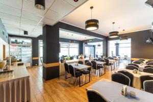 a dining room with tables and chairs in a restaurant at WYDMA Resort Medi & SPA - Normobaria in Mrzeżyno +53 photos
