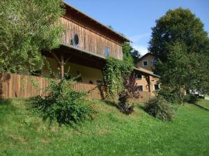 ein Haus mit einem Zaun und Bäumen davor in der Unterkunft Moierhof in Treffelstein