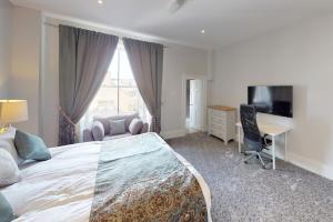 a bedroom with a bed and a desk and a television at The Townhouse in Cork