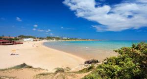 una playa con gente tirada en la arena y el agua en Latte&Miele, en Ragusa
