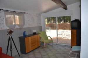 a living room with a television and a table and chairs at Gite L'Acacia in Lagorce