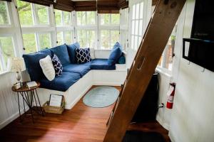 a living room with a blue couch in a window at The Cottage Treehouses in Hermann