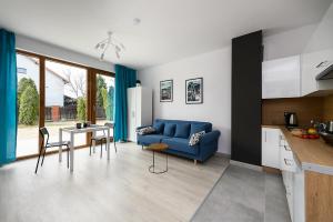 a living room with a blue couch and a table at Apartamenty RIO Oława in Oława