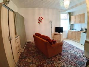 a living room with a couch and a television at Rosemede Holiday Flats in Blackpool