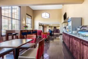 Comfort Inn & Suites في ماكومب: مطعم بطاولات وكراسي وبار