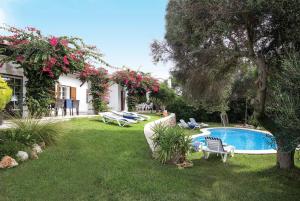 un patio con piscina y sillas y una casa en Victoria, en Binibeca