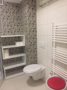 La salle de bains est pourvue d'une douche et de toilettes blanches. dans l'établissement Apartment Red Square, à Ljubljana