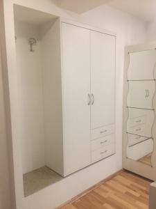 1 dormitorio con armarios blancos y espejo en Apartment Red Square, en Liubliana