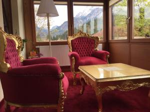un soggiorno con 2 sedie e un tavolino da caffè di Haus bei der Linden Ferienwohnungen a Schwangau