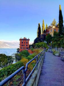 a walkway next to a body of water with buildings at Il porticciolo in Bellano